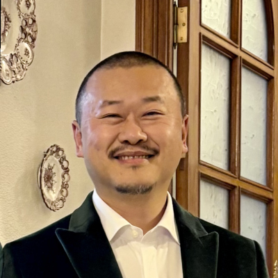 Weiwu wearing a green suit.